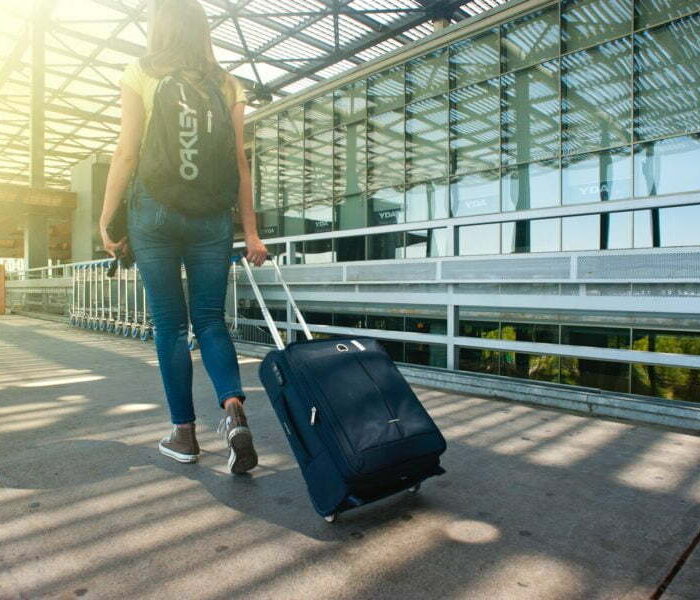 woman-walking-on-pathway-while-strolling-luggage-1008155