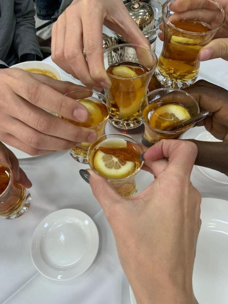 International students having tea together, showing inclusiveness in graduate school. Inclusiveness is a prerequisite when choosing the perfect grad school program.