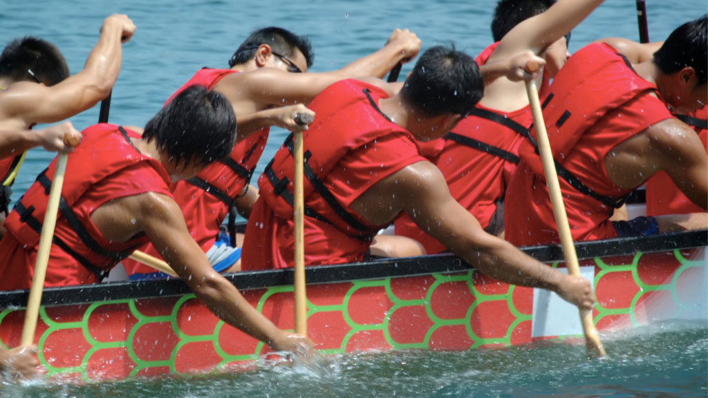 Dragon boat race participant are actively paddling the oat. It is one of the Traditions of the Chinese Dragon Boat Festival